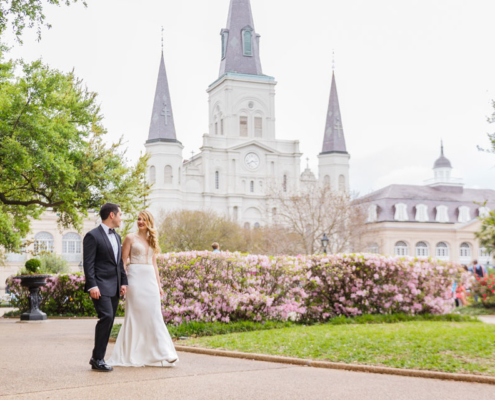 Bride and groom strolling in front of a castle mansion