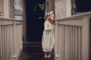 little barefoot girl peeking over banister