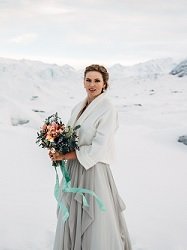 Bride with bouquet on glacier in Alaska for her wedding